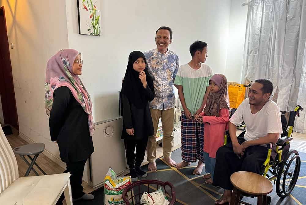 Rozi (tengah) melawat Azlan dan keluarganya di kediaman dekat Pangsapuri Ladang Tok Pelam.