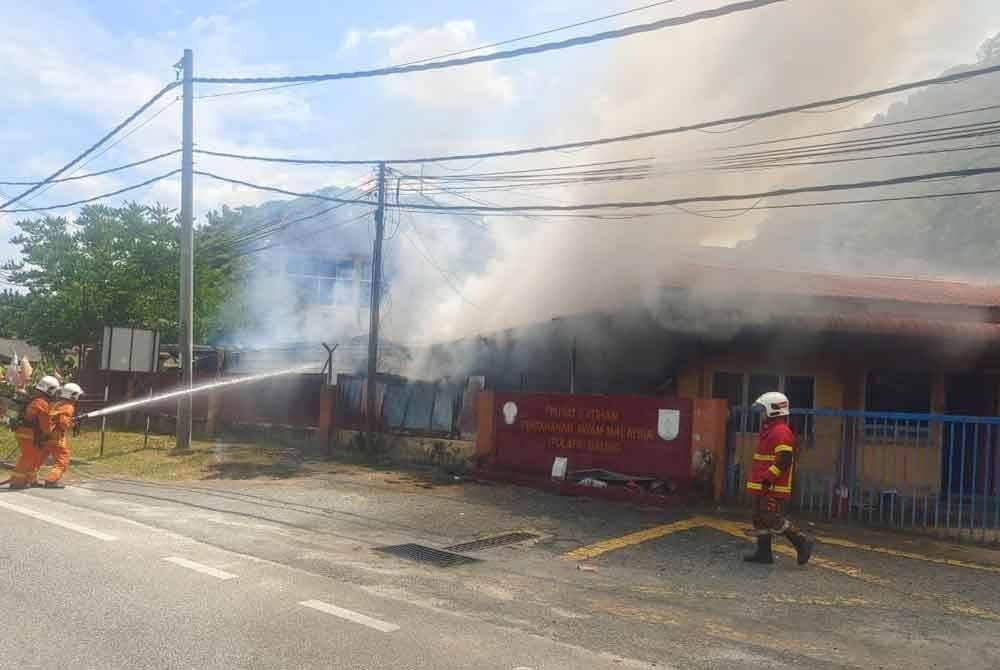Anggota bomba berusaha memadamkan kebakaran membabitkan bangunan APM Baling pada Rabu. Foto JBPM