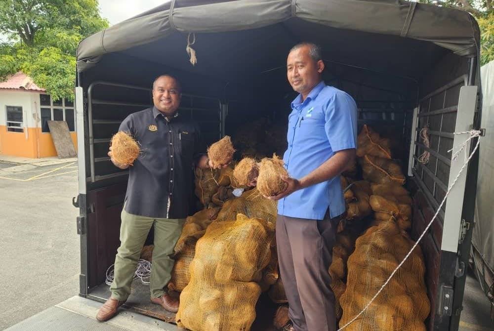 Muhamad Fadlee (kiri) menunjukkan kelapa yang diterima untuk kegunaan sepanjang minggu pertama Ramadan.