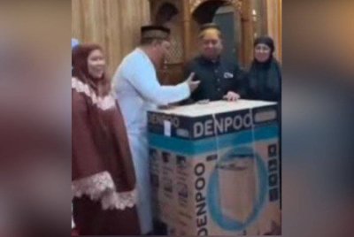 Salah seorang jemaah bertuah berjaya membawa pulang sebuah mesin basuh. Foto Agensi