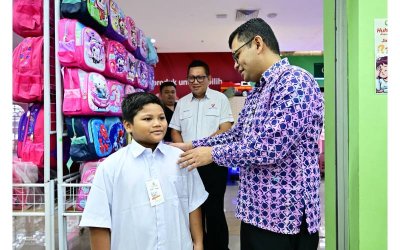 Timbalan Menteri Peralihan Tenaga dan Transformasi Air, Akmal Nasrullah melihat saiz baju sekolah seorang pelajar ketika salah satu program Program Santuni MADANI: Ceria Ke Sekolah (CKS) 2025.