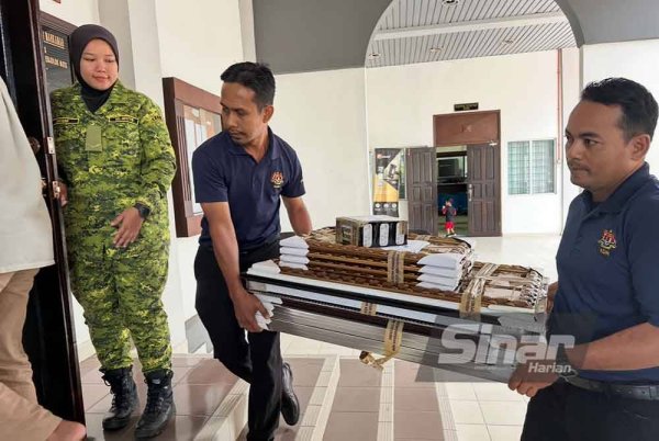 Bahan bukti bingkai gambar dibawa masuk ke bilik Mahkamah Kuala Krai. FOTO SINAR HARIAN-ADILA SHARINNI WAHID