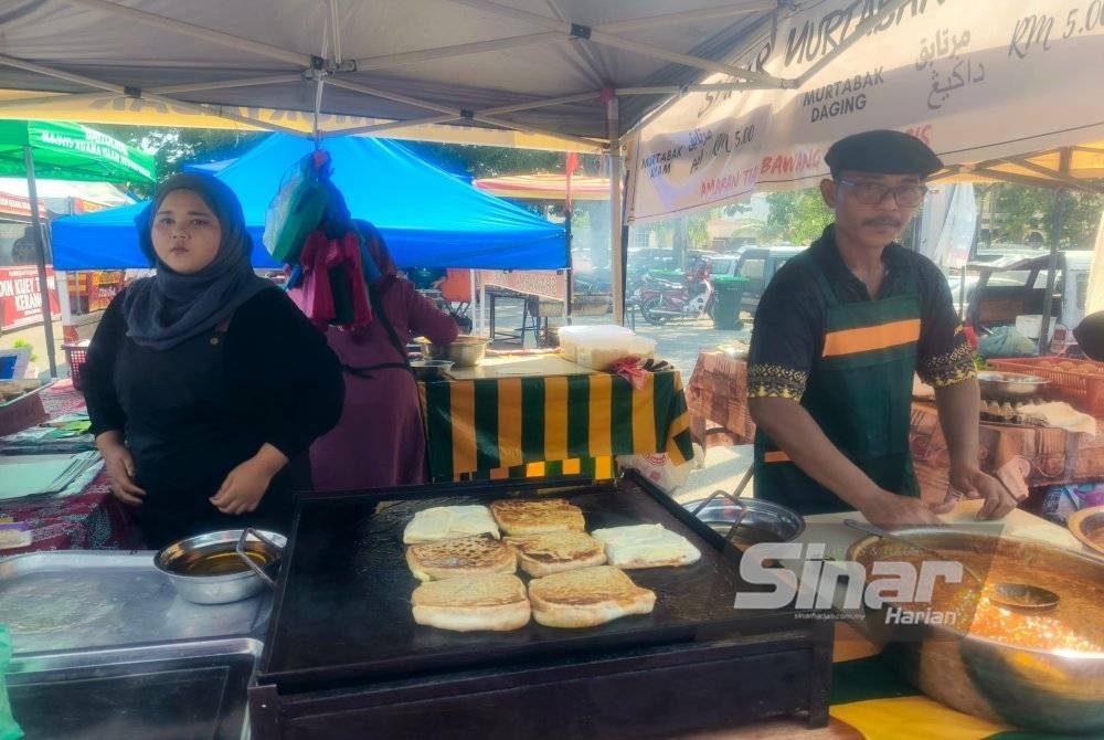 Zulkifli (kanan) semasa ditemui di gerainya di Bazar Ramadan Stadium Darul Aman, Alor Setar.