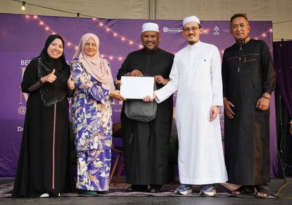 Ramli (tengah) menyaksikan Ahmad Rizal (dua dari kanan) menyerahkan komputer riba kepada Faridah (dua dari kiri) selaku wakil Pertubuhan Rahoma Darul Fakir Malaysia.