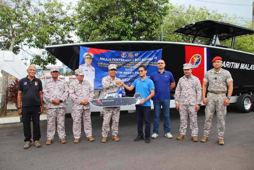 Saiful Lizan menerima penyerahan bot pemintas jenis IC 1170CC kurniaan Agong pada majlis penyerahan di Pos Maritim Teluk Gading,Rompin pada Rabu.