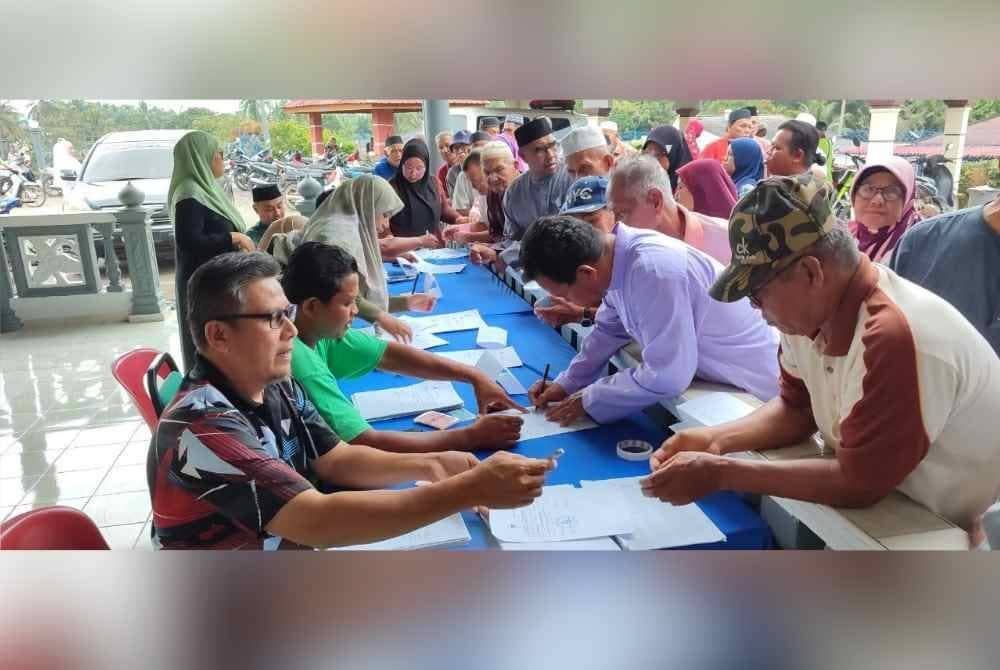 Antara penerima layak menerima sumbangan memeriksa nama masing-masing.