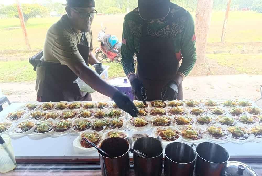 Shafri (kiri) sedang menghasilkan popia basah.