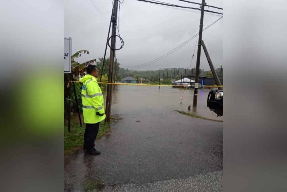 Anggota polis memantau kawasan dinaiki air.
