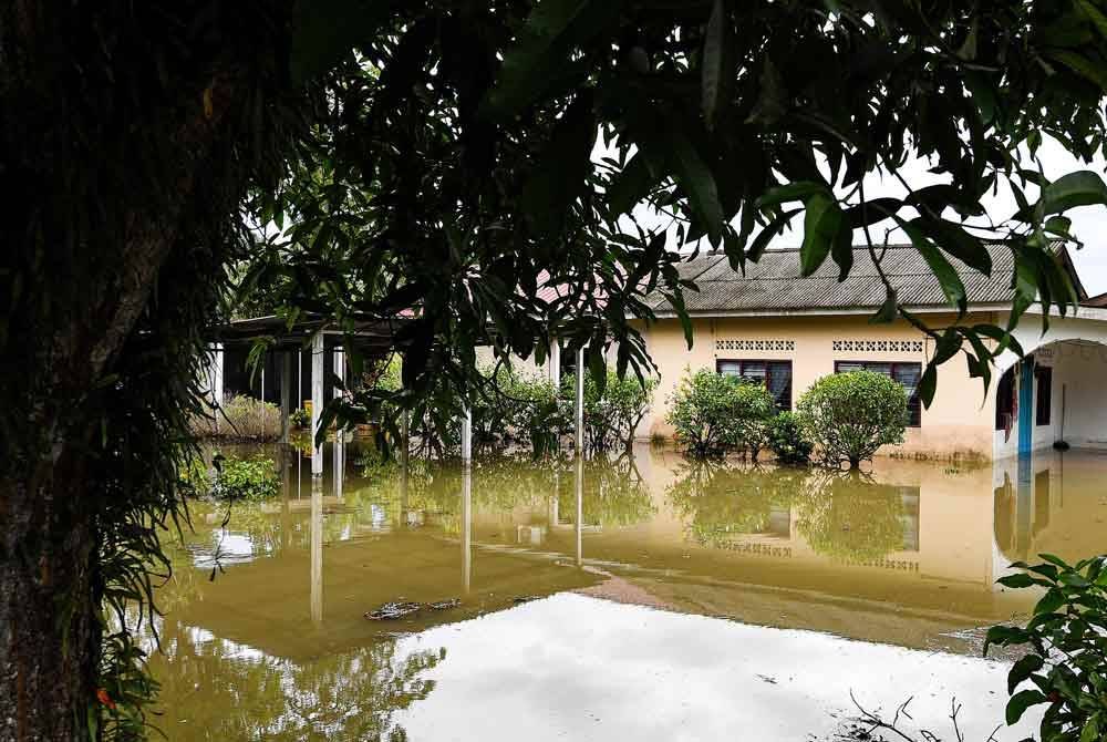 Keadaan di sekitar penempatan penduduk Kampung Segenting yang dinaiki air akibat limpahan air sungai berdekatan ekoran hujan lebat sejak Rabu. Foto Bernama