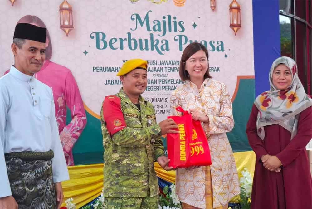 Sandrea (dua dari kanan) bersama Sayani (kanan) menyampaikan bakul kasih Ramadan sempena majlis berbuka puasa bersama warga JBPM Perak pada Khamis.
