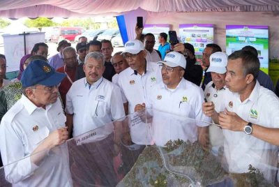 Ismail (tiga dari kiri) mengiringi Anwar ketika meluncurkan projek pembangunan infrastruktur bagi menyokong penanaman padi lima musim dalam dua tahun di Jerlun. Foto fail