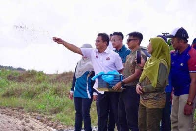 Zahari menabur benih padi pada program di Kahang, baru-baru ini.