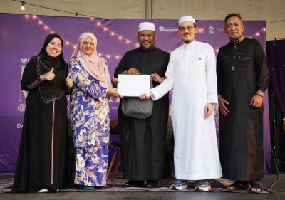 Ramli (tengah) menyaksikan Ahmad Rizal (dua dari kanan) menyerahkan komputer riba kepada Faridah (dua dari kiri) selaku wakil Pertubuhan Rahoma Darul Fakir Malaysia.