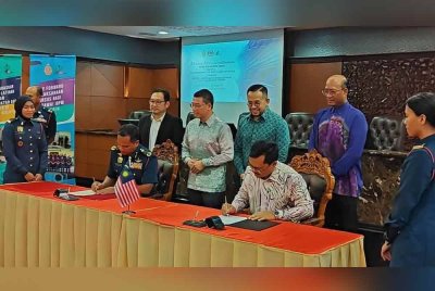 Kor Ming (berdiri, dua dari kiri) dan Steven (berdiri, tiga dari kiri) menyaksikan Majlis Menandatangani dan Pertukaran Nota Kerjasama antara NIOSH dan JBPM yang berlangsung di Parlimen pada Khamis.