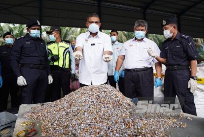 Saifuddin (tiga dari kanan) menunjukkan sisa peluru dan kelongsong yang ditemui di sebuah kilang e-waste di Telok Panglima Garang, pada Khamis. Foto ROSLI TALIB-SINAR HARIAN