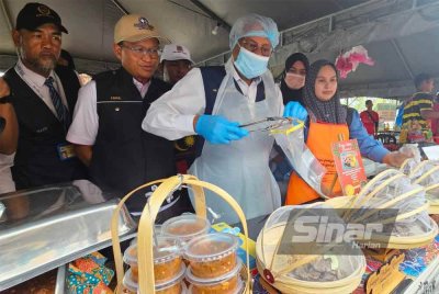Sivanesan (tengah) mengambil sampel makanan daripada salah sebuah gerai jualan di bazar Ramadan SIBC untuk dianalisis.