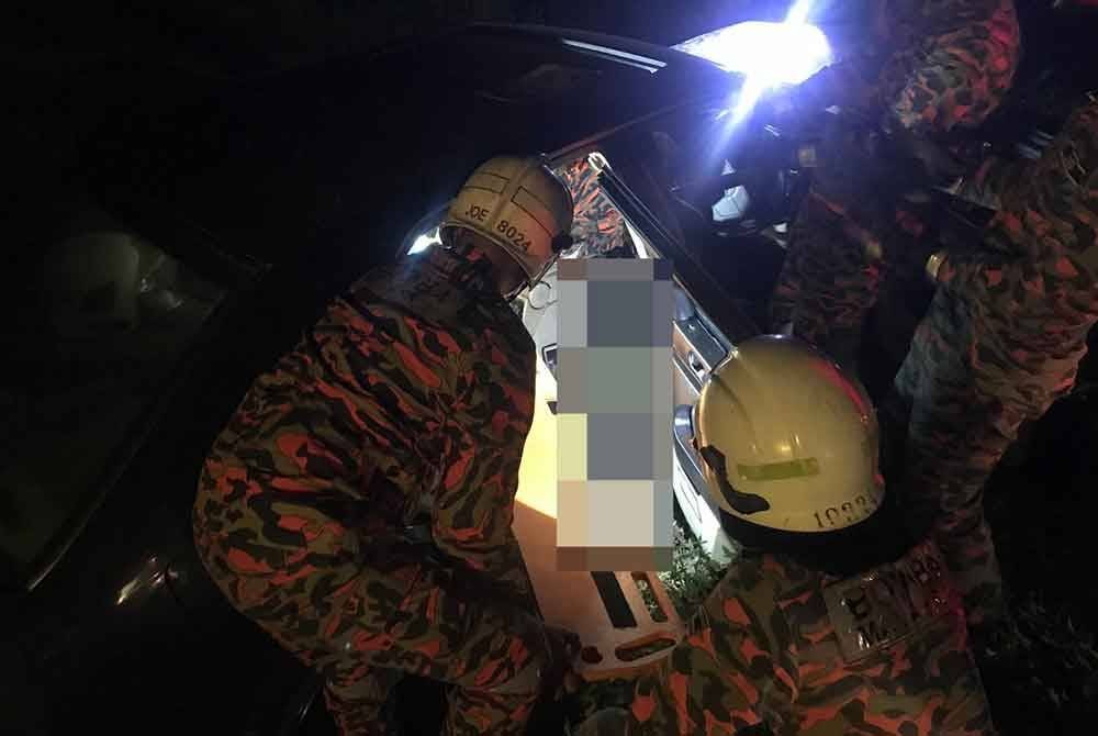 Anggota bomba membantu mengeluarkan mangsa yang tersepit dalam kemalangan membabitkan sebuah bas ekspres dan dua kereta di Jalan Kota Mersing, berhampiran Felcra Sungai Ara pada malam Khamis. - Foto JBPM Johor