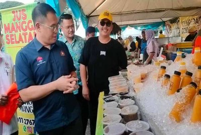 Tian Soon (kiri) meninjau salah satu gerai di bazar ramadan di Johor Bahru pada petang Khamis.