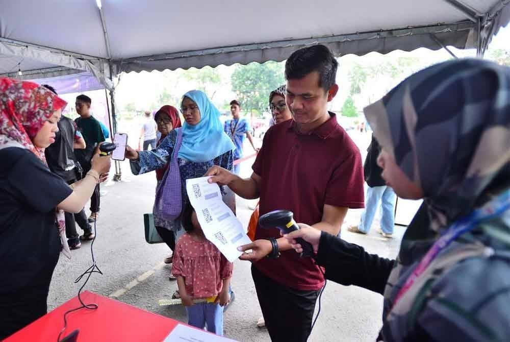 Orang ramai yang telah berdaftar, mengimbas kod QR untuk berbuka puasa secara percuma di Dataran Karangkraf.