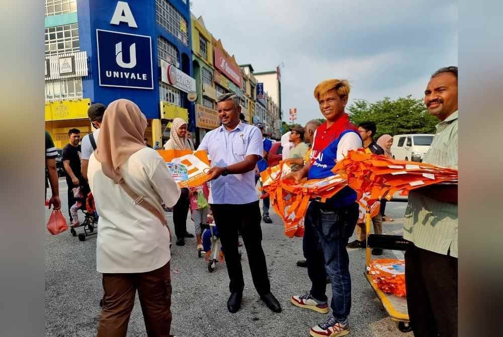 Arul Kumar memberi beg kitar semula kepada orang ramai yang datang bazar Ramadan baru-baru ini
