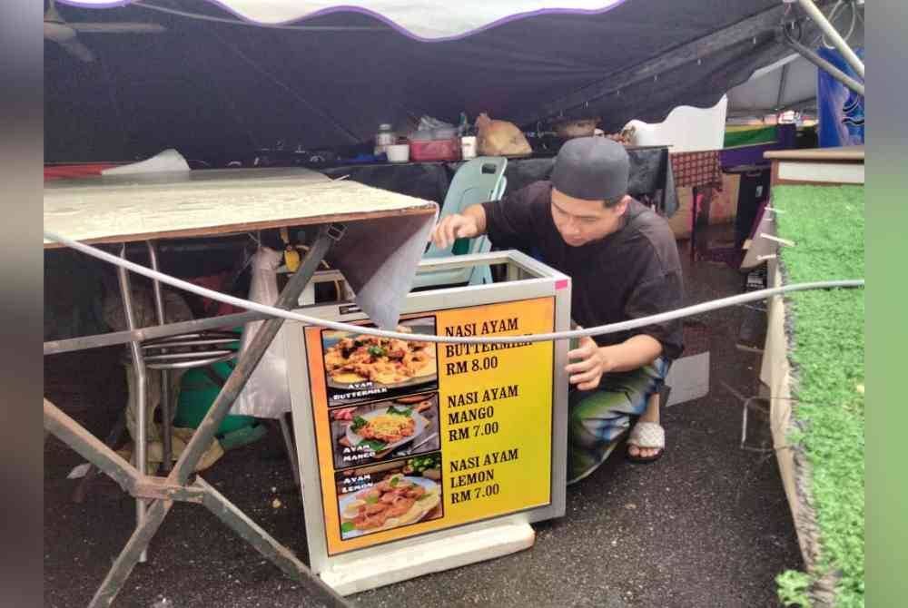 Nor Syazani Ikhwan melihat peralatan jualan di gerainya yang dihempap khemah dalam kejadian ribut awal pagi Sabtu