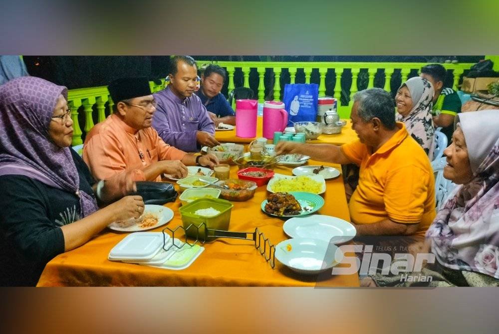 Amizar (dua dari kiri) dan isterinya, Norhida (kiri) bersahur bersama keluarga Alias (dua dari kanan).