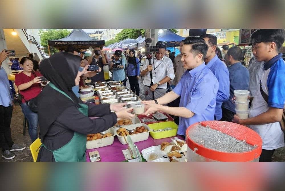 Arthur mengagihkan bubur kepada peniaga bazar Ramadan di Asia City, Kota Kinabalu.