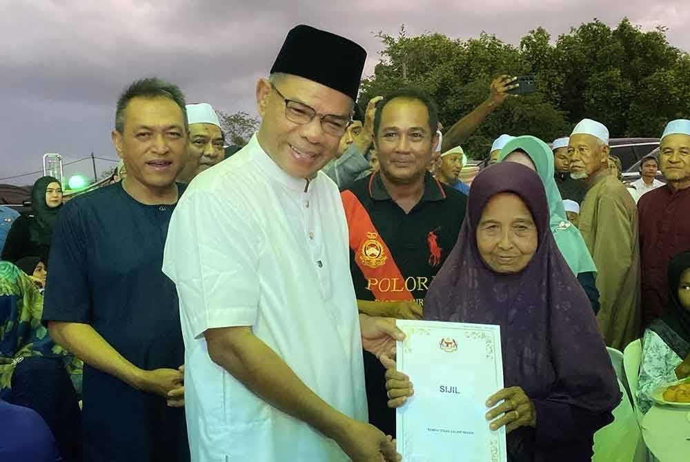 Saifuddin (dua dari kiri) menyerahkan sijil keputusan kewarganegaraan kepada penduduk dalam program terbabit pada Sabtu.