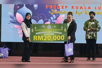 Pengurus Pusat Pakaian Hari-Hari, Mike Yee menyerahkan simbolik penyerahan sumbangan kepada Naib Pengerusi Perkep Kuala Lumpur, Datin Suriyanti Esa pada Program Amal Kesejahteraan Komuniti sempena Ramadan pada Sabtu.
