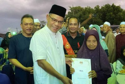 Saifuddin (dua dari kiri) menyerahkan sijil keputusan kewarganegaraan kepada penduduk dalam program terbabit pada Sabtu.