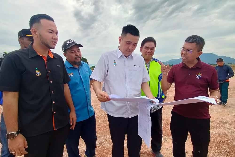 Baderul Amin (kanan) memberi penerangan kepada Moii Lye mengenai aktiviti tanah secara haram yang dilakukan di dua lot tanah di Permatang Ara, pada Ahad.