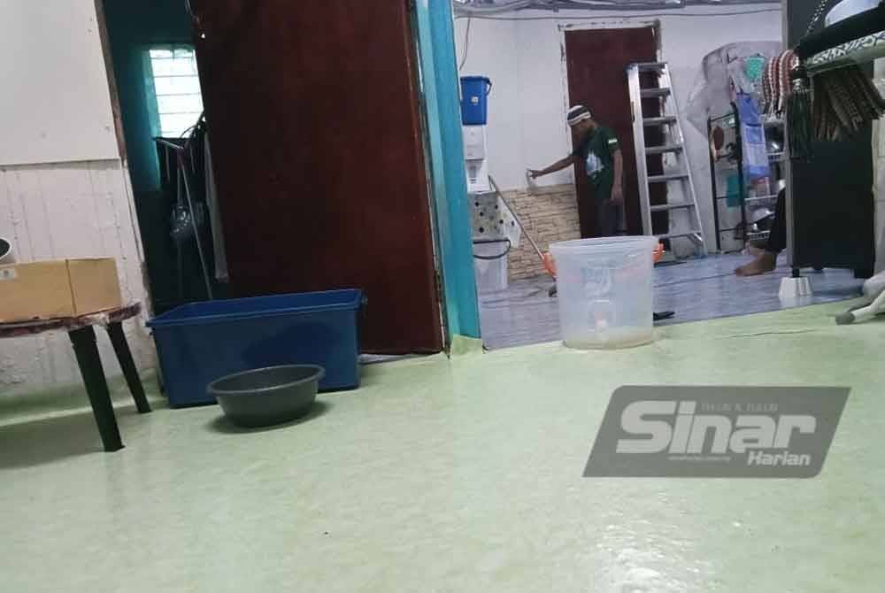 Othman terpaksa menggunakan baldi dan bekas untuk menadah air akibat bumbung yang bocor.