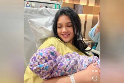 Atikah memeluk anaknya sambil tersenyum