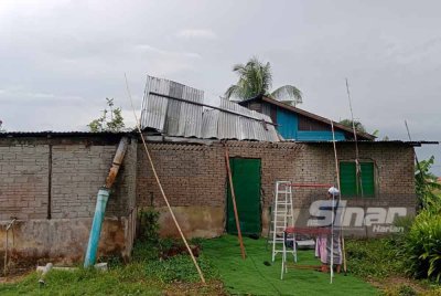 Othman melihat keadaan bumbung rumahnya yang rosak akibat ribut pada 21 Februari lalu.