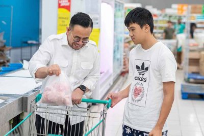 Steven (kiri) membawa Wan En membeli lauk untuk dimakan.