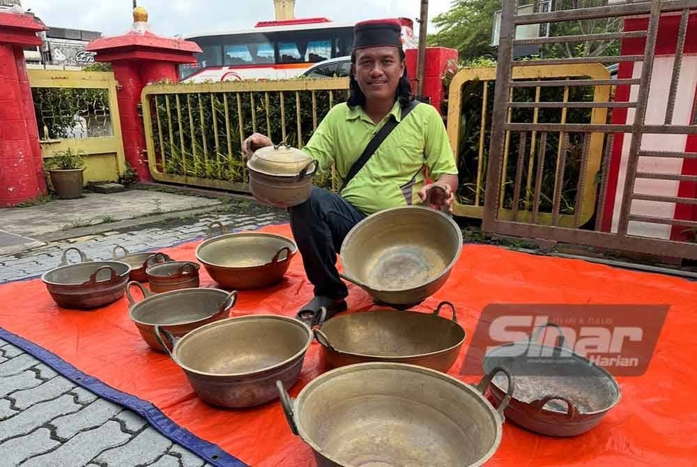 Mohd Khairullah menunjukkan belanga dan kuali tembaga yang dikumpulnya.