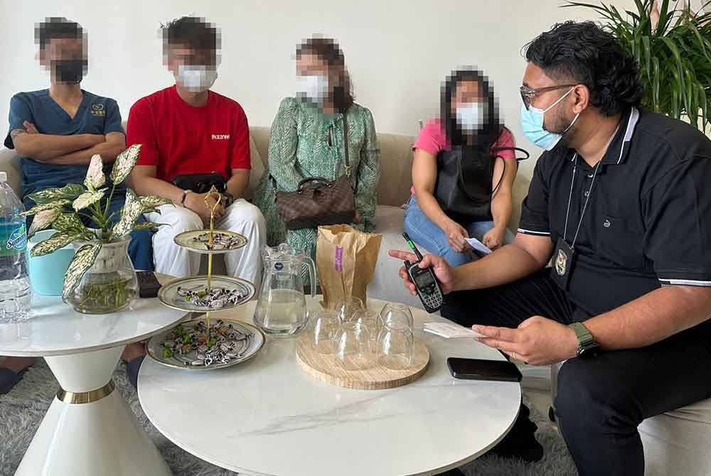 Pegawai Imigresen Kuala Lumpur melaksanakan proses dokumentasi terhadap individu yang ditahan di sebuah unit kondominium di Bukit Jalil, Kuala Lumpur pada Isnin.