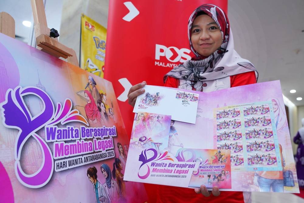 Petugas Pos Malaysia, Nurul Hasanah, 34, menunjukkan Setem Hari Wanita Antarabangsa Tahun 2025 yang dilancarkan di Pusat Dagangan Dunia Kuala Lumpur.