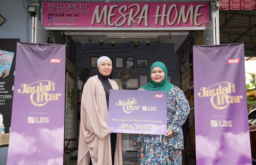 Norazian (kanan) menyampaikan sumbangan kepada Faezah pada program Jaulah Iftar Komuniti yang diadakan di Mesra Home.