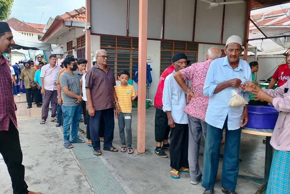 Mohamed Rizwan (kiri) ketika meninjau pengedaran nombu kanji yang dilakukan.