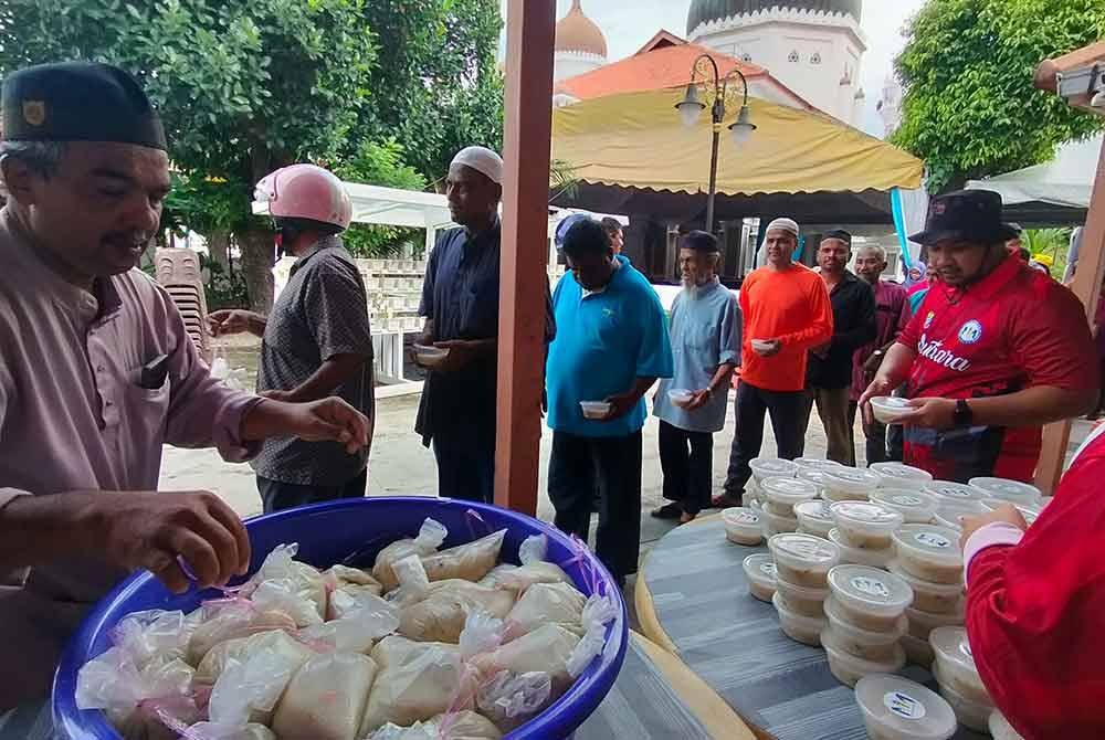 Orang ramai berbaris bagi mendapatkan nombu kanji yang diedarkan secara percuma