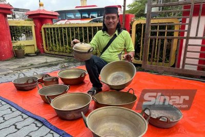 Mohd Khairullah menunjukkan belanga dan kuali tembaga yang dikumpulnya.