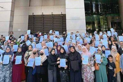 Ena (tengah) bersama jemaah umrah yang terkandas berkumpul di hadapan bangunan AGC Putrajaya bagi sesi penyerahan memorandum pada Isnin.