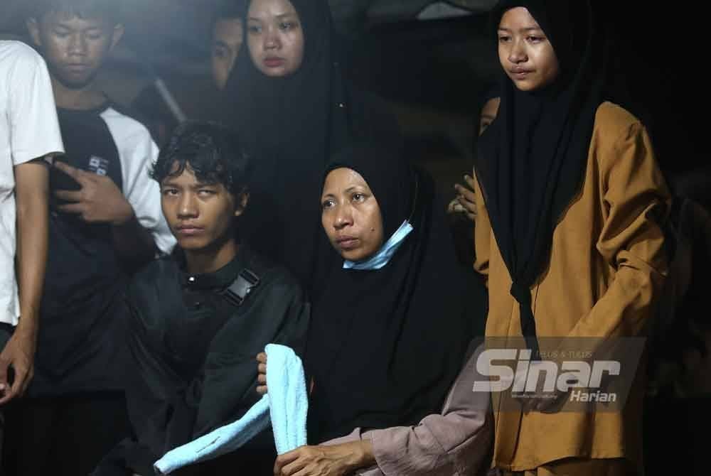 Ibu Allahyarham (duduk) dan anak-anak lain yang hadir ke Tanah Perkuburan Islam Maqbarah Salimah Taman Zaitun Indah di Sikamat.