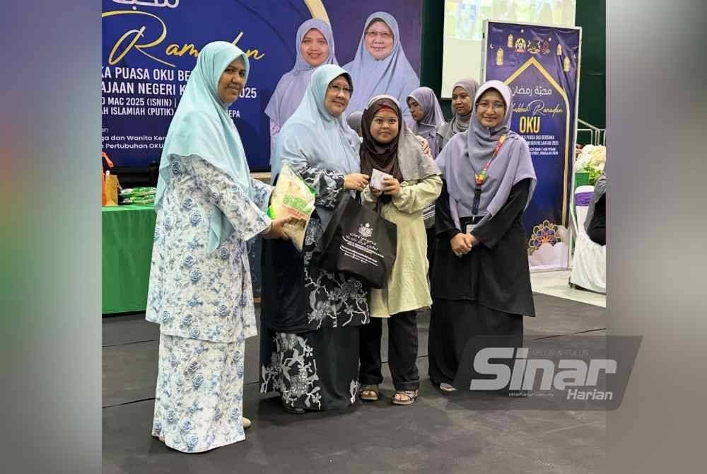 Rohani (dua dari kiri) menyampaikan sumbangan kepada penerima OKU.