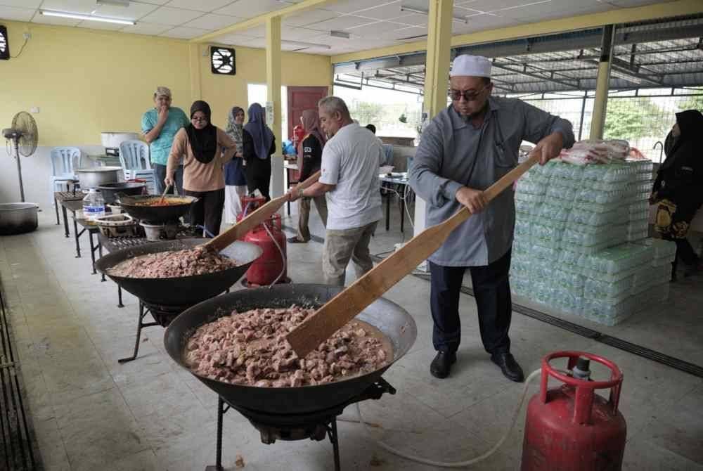 Orang ramai membantu memasak gulai kawah dan juadah lain secara gotong-royong.