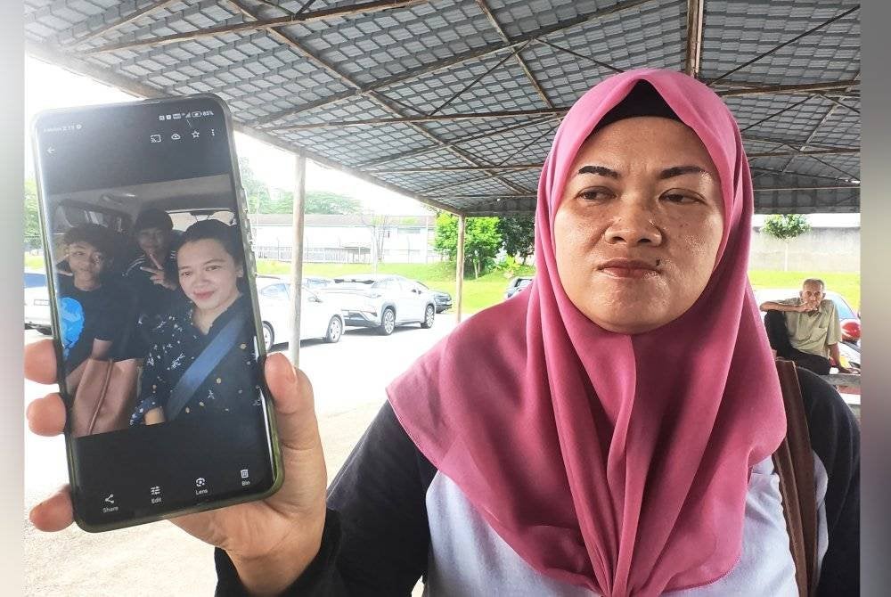 Haslinda menunjukkan gambar dengan kedua-dua anaknya.