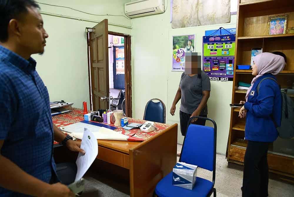 Dua pegawai SPRM bertanyakan sesuatu kepada seorang petugas di sebuah klinik dalam serbuan Op Outlander dan Op Birth pada Selasa. Foto SPRM