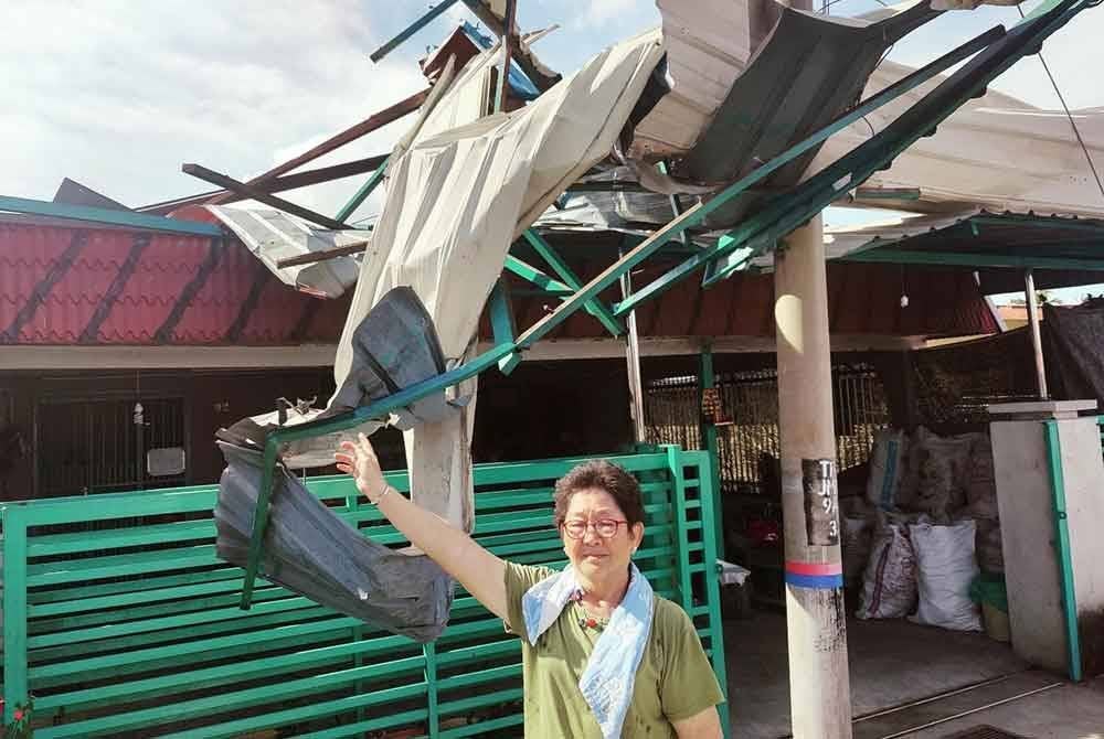 Luan Ngo menunjukkan bumbung zink rumahnya yang diterbangkan angin dalam kejadian ribut pada Selasa.