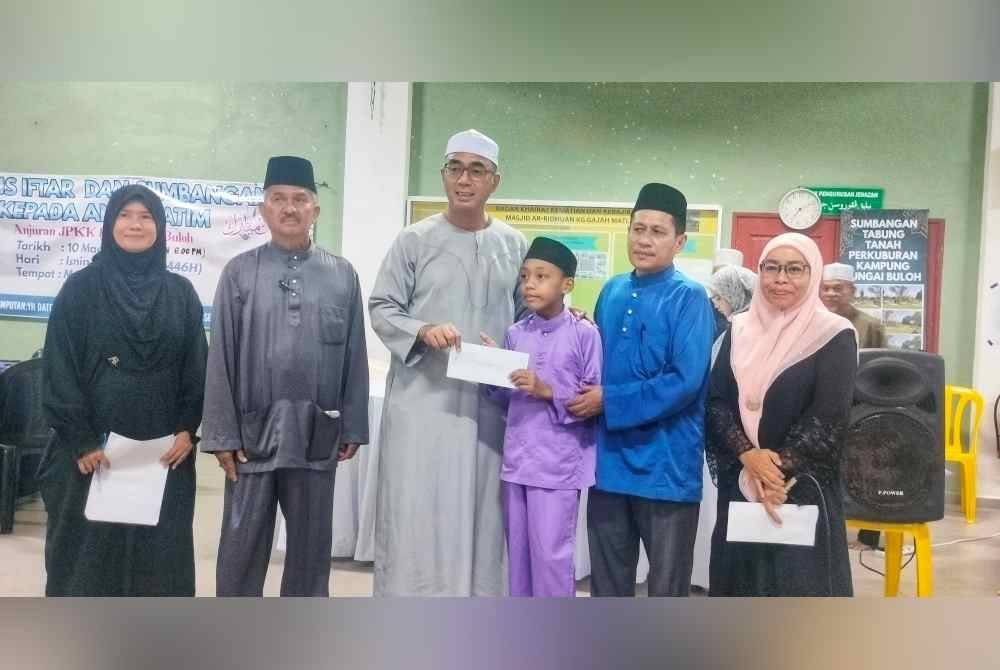 Ridzuan(tiga dari kiri) bersama Ahmad Jafri (dua dari kanan) ketika menyerahkan sumbangan kepada anak yatim.
